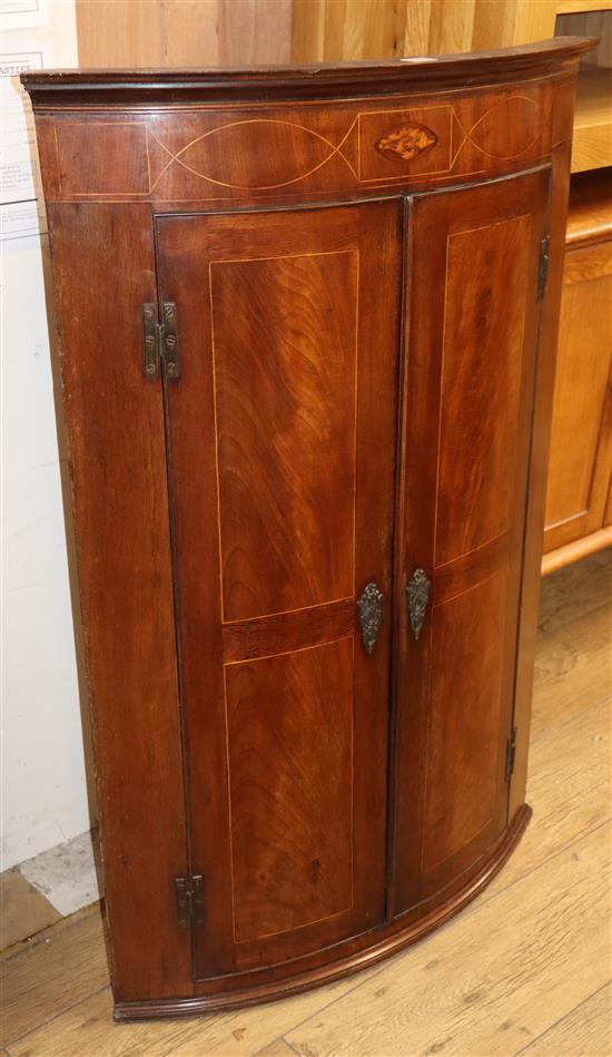 A late 19th century inlaid mahogany bow front hanging corner cupboard W.110cm